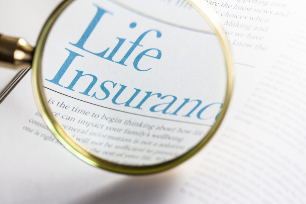 Life insurance written on paper under a magnifying glass