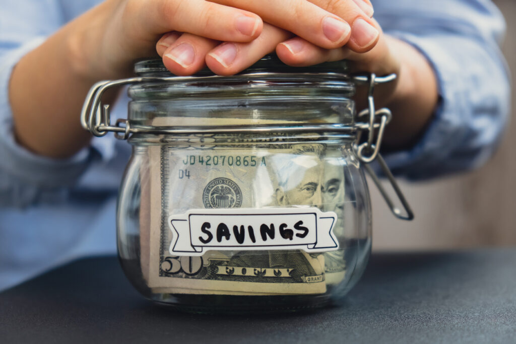 Mason jar with money in it labeled savings. Save money